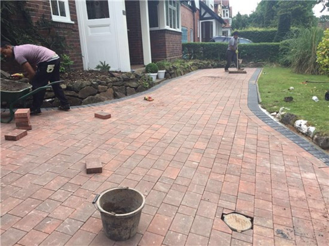 men laying block paving.